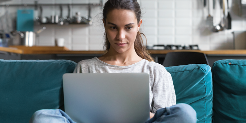 woman sitting on couch with laptop